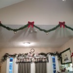 Classic garland, bows, and bulbs droop over dining entrance way